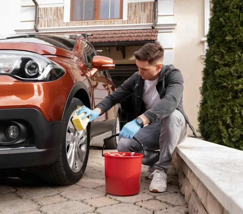 Lavage auto à domicile Les Premiers Sapins : professionnel intervenant sur un véhicule